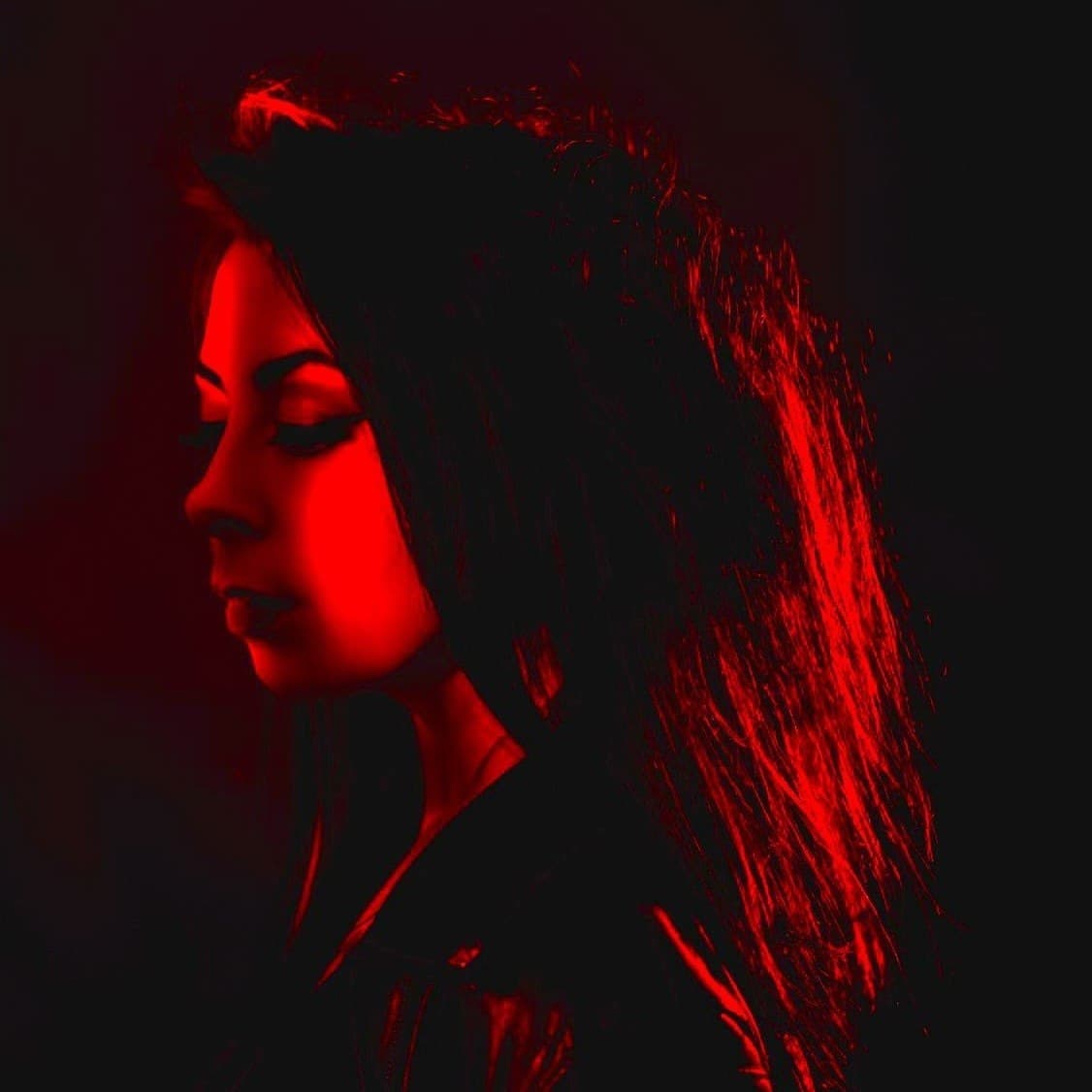 Mari Kattman lit in red, eyes lowered